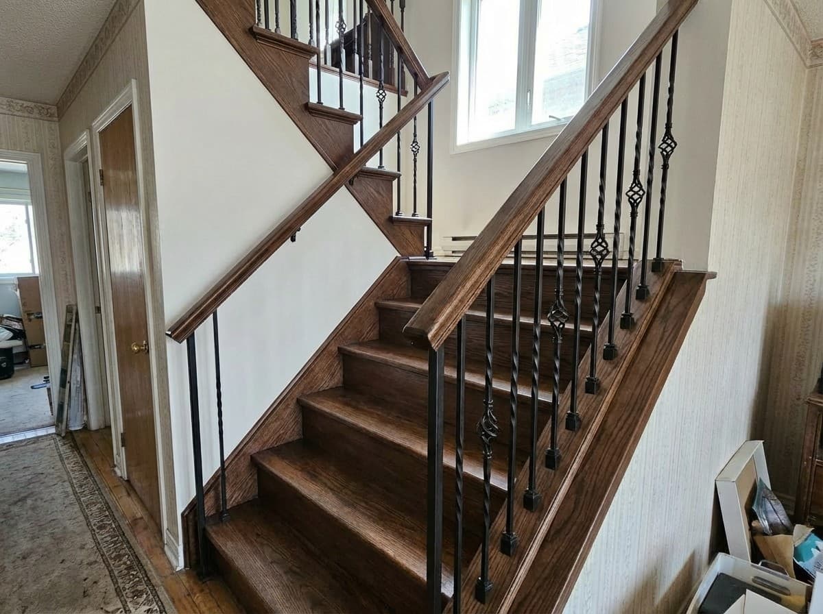 After: Modern wrought iron balusters with stained handrail